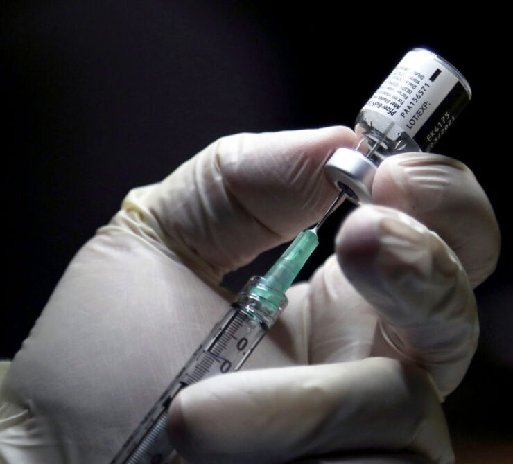 A healthcare worker prepares to administer a Pfizer/BioNTEch coronavirus disease (Covid-19) vaccine at The Michener Institute, in Toronto, Ontario on December 14, 2020. - Ontario, Canada's most populous province and one of the hardest hit by the pandemic, had 1,940 new cases and 23 deaths on Monday.  The province is expected to give its next doses to nursing home workers as a priority, according to media reports. (Photo by CARLOS OSORIO / POOL / AFP) (Photo by CARLOS OSORIO/POOL/AFP via Getty Images)